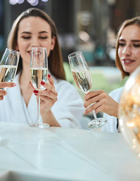 Kobiety na wieczorze panieńskim z lampką szampana w ręku