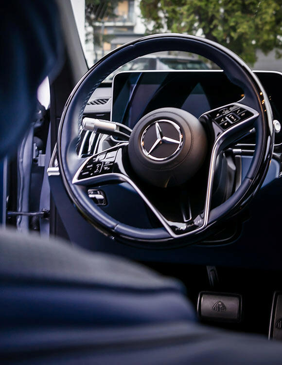 Ekskluzywne wnętrze Mercedesa Maybach z elegancką kierownicą i cyfrowym kokpitem – idealne na luksusowe transfery lotniskowe Gdańsk.