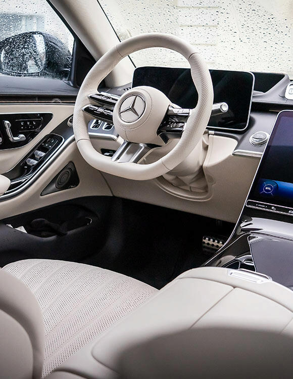 Luksusowe wnętrze Mercedesa S-klasa z jasną, skórzaną tapicerką i nowoczesnym panelem sterowania – idealne do ekskluzywnych transferów lotniskowych w Warszawie.